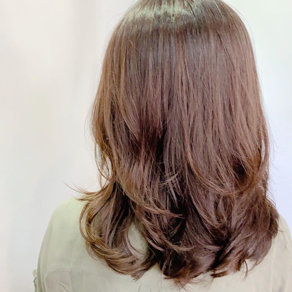 Frisuren mittellang: Frau mit braunem schulterlangem Haar