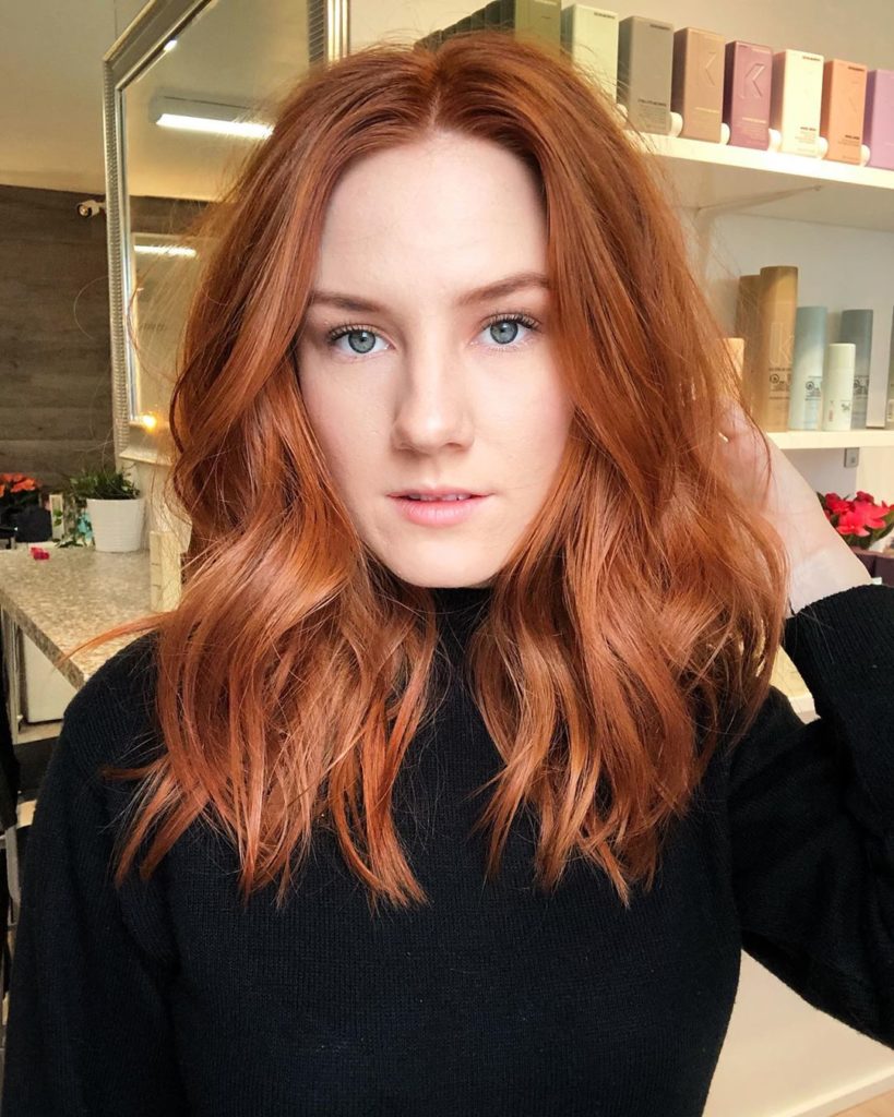 Frisuren mittellang: Frau mit roten, schulterlangen Haaren