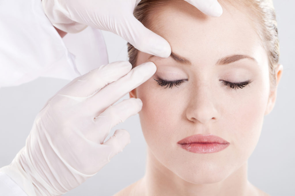 Schönheitsoperation: Frau wird am Gesicht untersucht