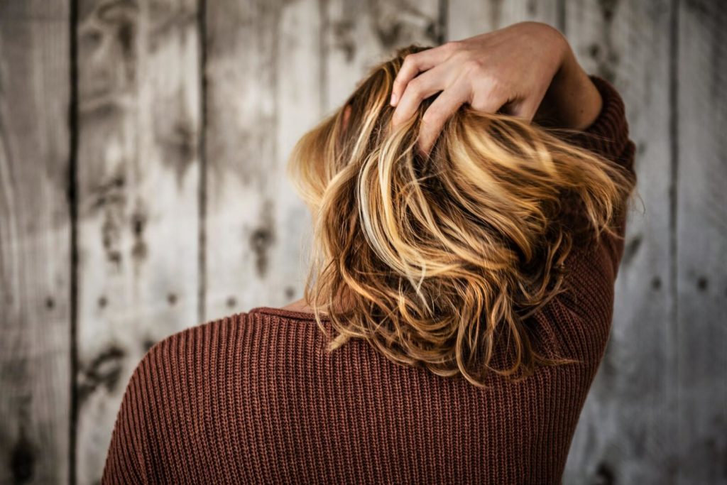 Professionelle Haarpflege: Frau fasst sich ins Haar