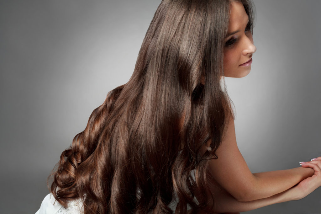 Haarpflege im Winter: Frau mit dunkelbraunem glänzendem Haar